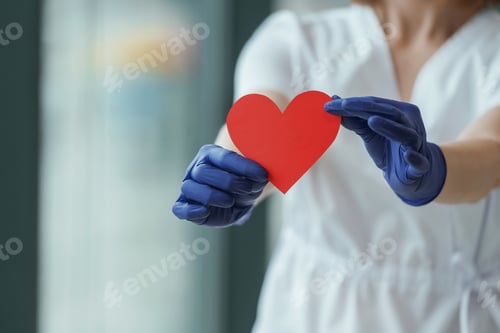 Preview: Female doctor is holding heart shaped paper, conception of cardiology