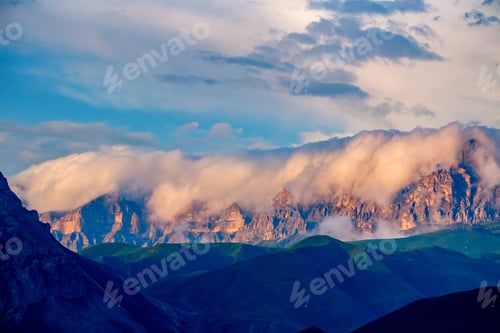 Preview: Scenic view of foggy mountains. Sunlit rocks and clouds