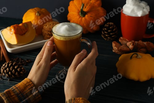 Preview: Coffee, cookies in female hand and pumpkins on gray background