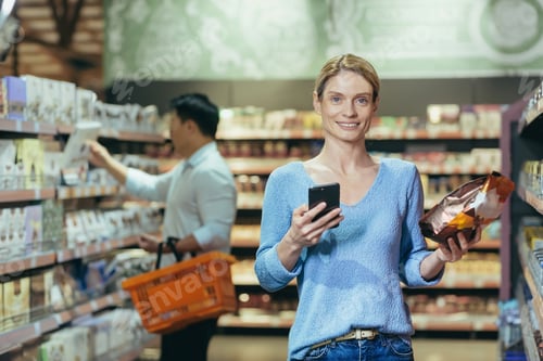 Preview: Portrait of a woman buyer in a supermarket in the grocery department, a blonde housewife chooses