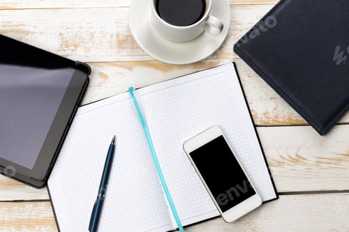 Preview: Workspace setup with coffee, tablet, and notebook on wooden table in bright lighting