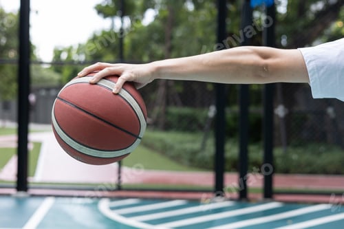 Preview: Young Man Holding Basketball on Court