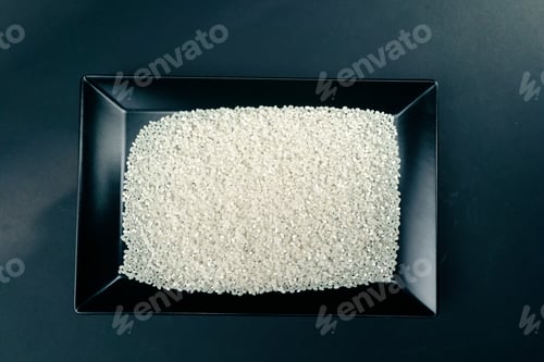 Preview: top shot white round rice lies on black and blue background on a black long flat plate Japanese