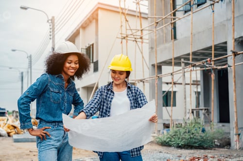 Preview: Young female architector and engineers working on building site.