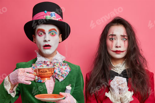 Preview: Frightened insane hatter spends free time on tea party. Brunette woman wears makeup of ghost vampire