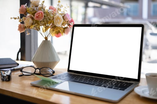 Preview: Mockup computer laptop, glasses, coffee cup and flower pot on wooden table.