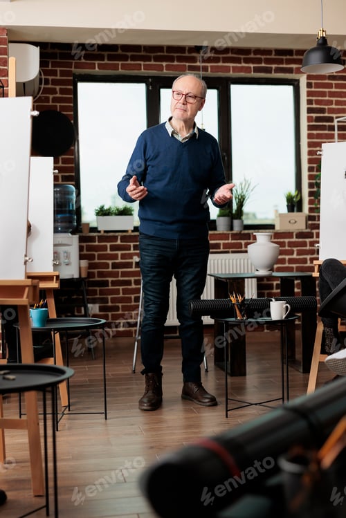 Preview: Senior man teaching art at group class