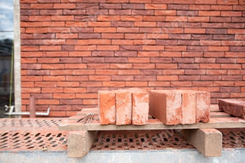 Visualização: uma nova casa está sendo construída, o início da alvenaria com tijolos vermelhos, construção