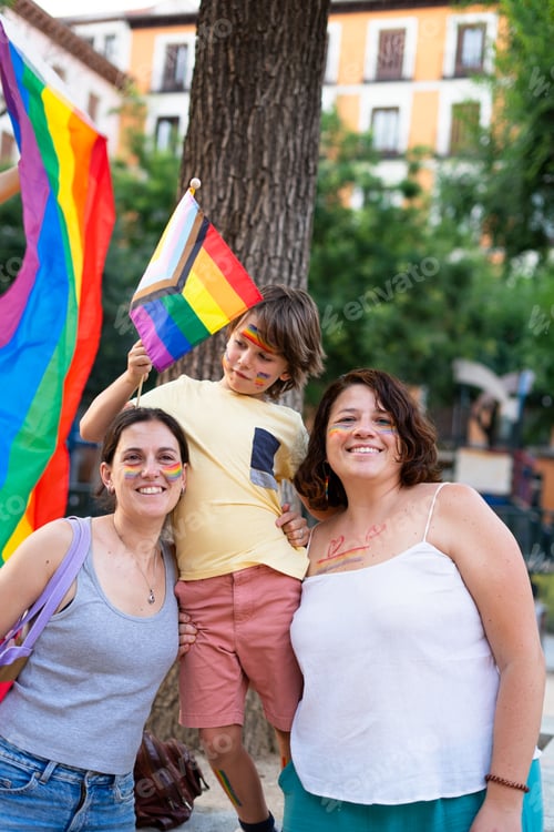 Preview: Lesbian family of two mothers and a child on gay pride day with lgtb flags