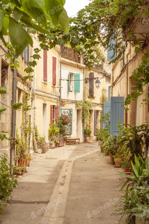 Preview: Narrow alley with historic medieval buildings and lush greenery and plants