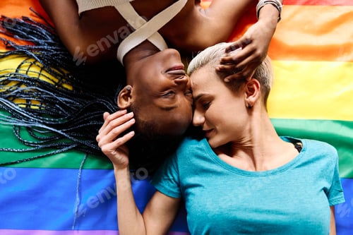 Preview: Lesbian couple lying above an lgtb rainbow flag