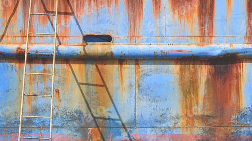 Preview: Rusty metal hull of the old nautical vessel with ladder at shipyard during improvement and renovatio