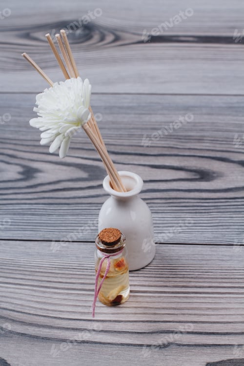 Preview: Aromatherapy sticks and decorative spa flower in a white ceramic vase.