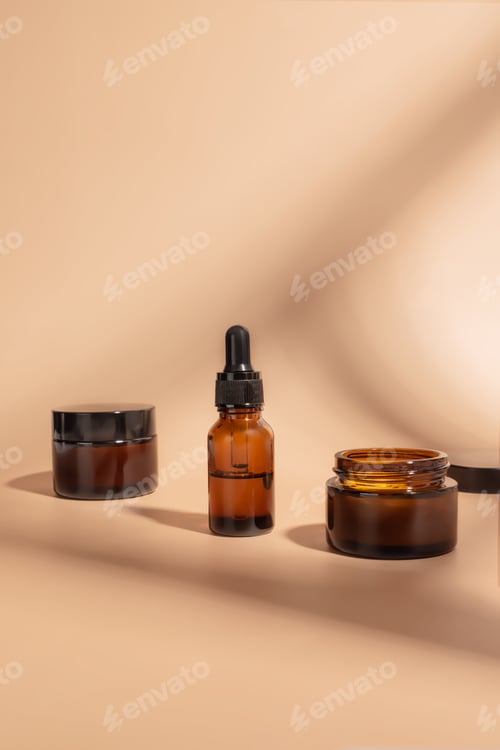 Preview: Cosmetics packaging. Set of different cosmetic bottles of cream or serum on a beige background. B