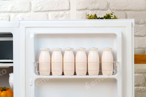 Preview: White Milk Bottles Stored in a Refrigerator Door Shelf