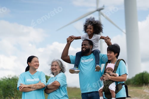 Preview: Volunteers walking by wind turbines during a sustainable energy charity event.