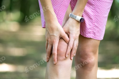 Preview: Woman holding her knee with hands having strong pain