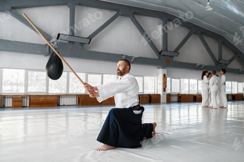 Preview: Confident and strong mature aikido master training with bokken Japanese sword