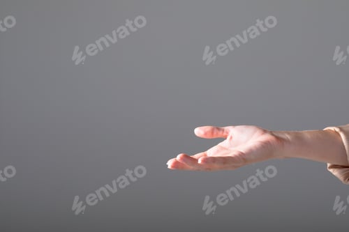 Preview: Midsection of caucasian businesswoman reaching with her hand, isolated on grey background