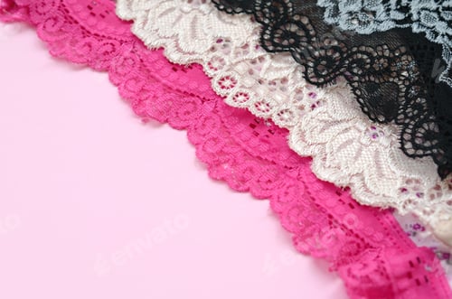 Preview: White, black and pink women underwear with lace on pink background close up with copy space