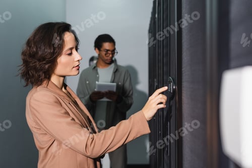 Preview: technician making diagnostics of server in data center near blurred african american colleague with