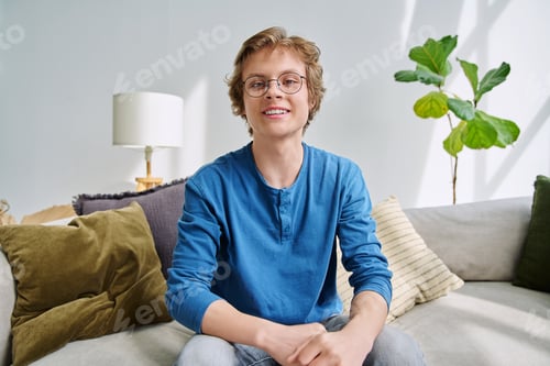 Preview: Webcam portrait male student teenager with glasses, sitting at home