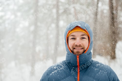 Preview: Smiling man enjoying solo winter hike in snowy forest