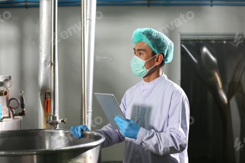 Preview: worker controlling the work of machine in production line at beverage industry.