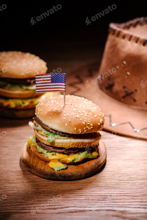 Preview: tasty burgers on wooden table with american cowboy hat