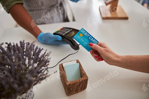 Preview: Woman using her bank card for buying flowers