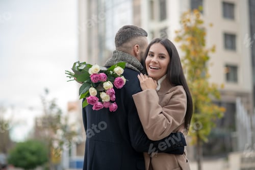 Preview: Joyful young woman holding beautiful flower bouquet