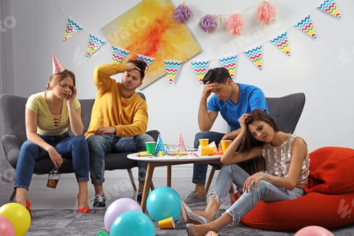 Preview: Group of friends suffering from hangover in messy room after party