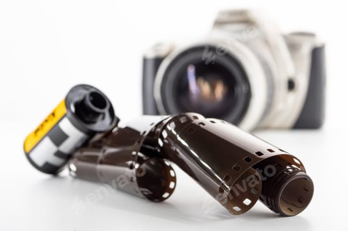 Preview: Single lens reflex camera and a film roll on a white background.
