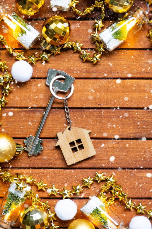 Preview: Key to house with a keychain tiny home on wooden background with Christmas decor layout. Gift for Ne