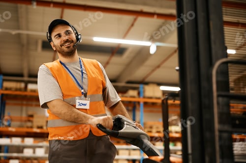 Preview: Happy warehouse worker using pallet jack at storage compartment.