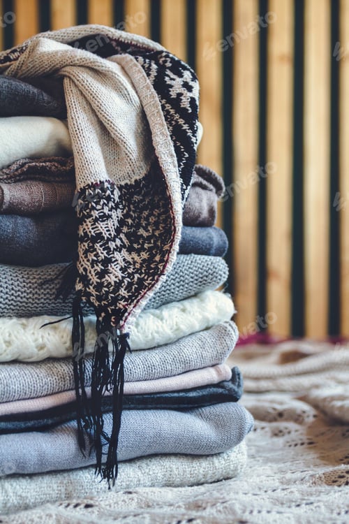 Preview: A stack of cozy warm winter clothes lies on the bed