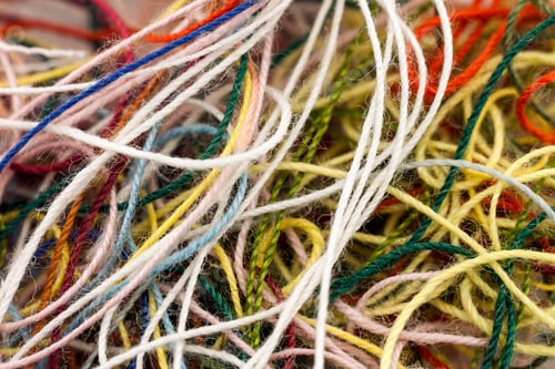 Preview: Multi-colored tangled colorful needlecraft silk thread rope. Macro shot. Abstract colors background