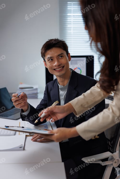 Preview: Business colleagues discussing financial data during office meeting