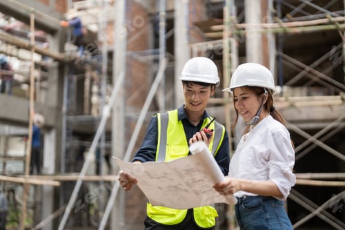 Preview: engineering and construction managers discussing project blue print on the table at construction