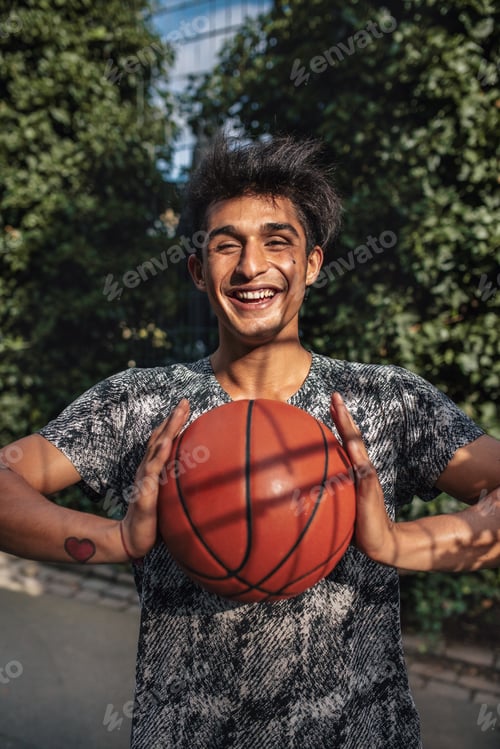 Preview: Smiling young man passing basketball