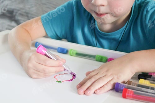 Preview: child's hands drawing with colored felt-tip pens on white paper