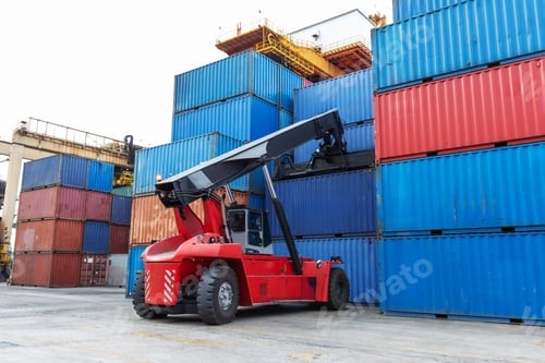Preview: Two trucks and a reach stacker operate in a busy container yard