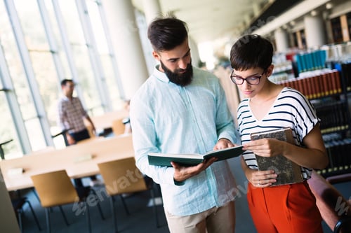 Preview: Young attractive students spending time in library