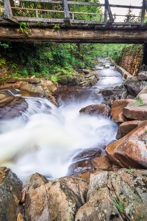 Preview: Rushing mountain stream under the wooden bridge