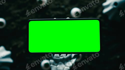 Preview: Skeleton Hand Holds Smartphone With Eyeballs On Ground