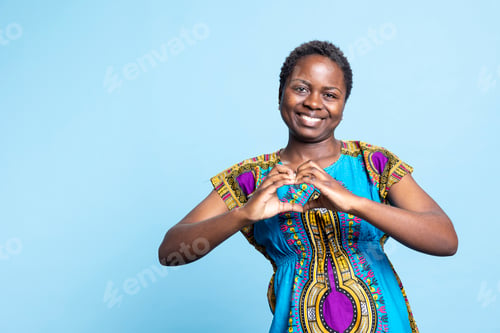 Preview: Young person creating heart shape gesture in the studio