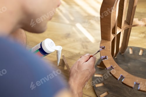 Preview: close up applying glue on the wood. Carpenter at work using glue in his workshop.