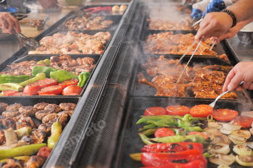 Preview: Beef and chicken steaks on the grill with flames.