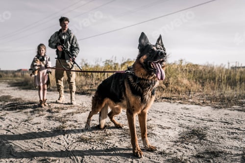 Preview: selective focus of german shepherd dog near armed man and kid, post apocalyptic concept