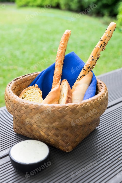 Preview: Bread loaf food snack in basket with blue napkin and white sauce